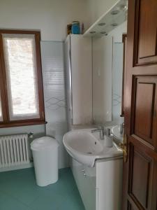 een witte badkamer met een wastafel en een toilet bij Casa Firmina Appartamento Santa Maria Maggiore in Santa Maria Maggiore