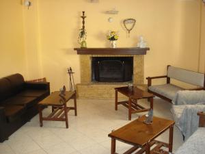 a living room with a fireplace with couches and tables at GOLDEN BEACH in Souvala