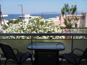 a table and chairs on a balcony with white flowers at GOLDEN BEACH in Souvala