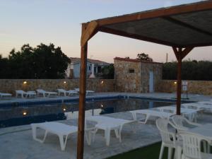 a group of white tables and chairs next to a pool at GOLDEN BEACH in Souvala