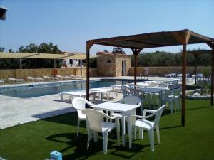 a group of tables and chairs next to a pool at GOLDEN BEACH in Souvala