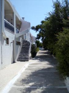 a building with stairs and trees next to a street at GOLDEN BEACH in Souvala