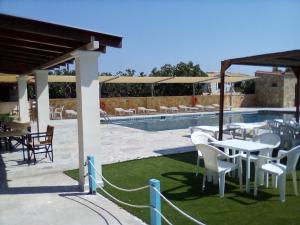 a patio with a table and chairs next to a pool at GOLDEN BEACH in Souvala