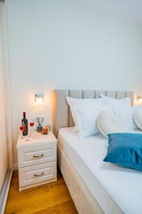 1 dormitorio con cama blanca y mesita de noche en Vibrant Oasis in the Center of the City, en Bucarest