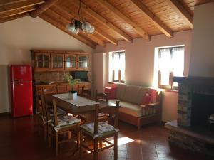uma cozinha e sala de estar com uma mesa e um frigorífico vermelho em Chalet Buonriposo em Cremia