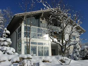 a house with snow covered trees in front of it at Ferienwohnungen Christa Grabmeier in Grainet