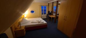 a hotel room with a bed and a desk and a room at Ephesus am Weserwehr in Drakenburg