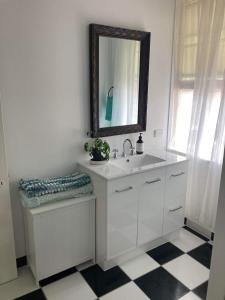een witte badkamer met een wastafel en een spiegel bij The Old Station Masters House in Maryborough