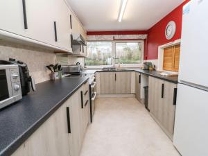 a large kitchen with wooden cabinets and black counter tops at Flat 6 in Falmouth