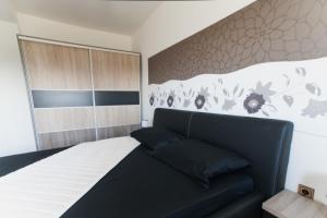 a bedroom with a bed with a black couch at Apartments Toka in Petrcane
