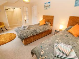 a bedroom with two beds and a mirror at Flat 6 in Falmouth