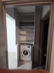 a washing machine in a room with a mirror at Apartament 2 camere in Bucharest
