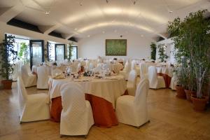 a banquet hall with white tables and white chairs at Splendid Hotel La Torre in Mondello