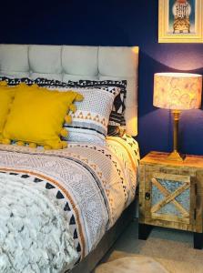a bedroom with a bed with yellow pillows and a lamp at Lido's View in Bristol