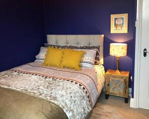 a blue bedroom with a bed with yellow pillows at Lido's View in Bristol
