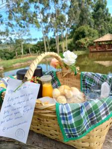 kosz piknikowy z chlebem i sokiem oraz znak w obiekcie Pousada Erva Doce w mieście Monte Alegre do Sul