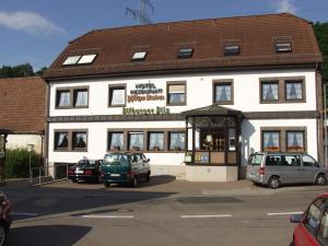 ein weißes Gebäude mit davor geparkt in der Unterkunft Hotel-Restaurant-Pfaelzer-Stuben in Bruchmühlbach-Miesau