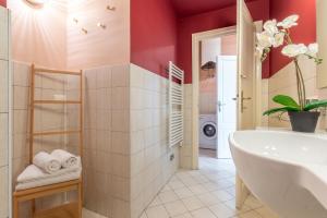 a bathroom with a white tub and red walls at Wine Apartments Florence Pinot in Florence