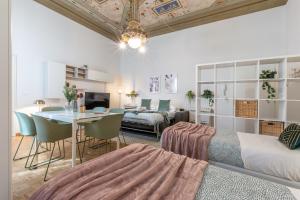 フィレンツェにあるWine Apartments Florence Pinotのベッドルーム1室(ベッド1台、テーブル付)、リビングルームが備わります。