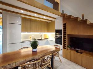 uma cozinha com uma grande mesa de madeira e cadeiras em Ocean House em Ovar
