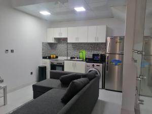 ein Wohnzimmer mit einem Sofa und einer Küche in der Unterkunft Family-Friendly Villa 1br with Play Area+Pool. UAE in Dubai