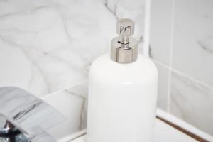 een witte fles zeep in de badkamer bij Fabulous 5 Bed House w Parking in Manchester