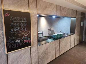 uma cozinha de restaurante com um quadro negro na parede em Somerset Future Center Wuhan em Wuhan