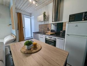 a kitchen with a table and a white refrigerator at Le Studio Pop in Paray-le-Monial