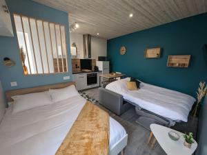 a room with two beds and a table in it at Le Studio Pop in Paray-le-Monial