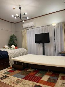 a living room with a table and a flat screen tv at Best Shinjuku Modern Full-furnished Family size Apartment4 ONLY 2min to Shinjuku by Train in Tokyo