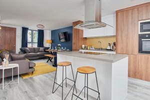 a kitchen and living room with a counter and stools at Fabulous 5 Bed House w Parking in Manchester