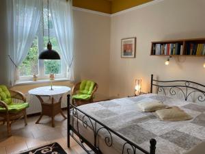 een slaapkamer met een bed en een tafel en stoelen bij Villa Schulenburg in Putbus auf Rügen in Putbus