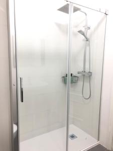 a shower with a glass door in a bathroom at Apartamento con vistas al mar en Primera Línea. in Muros +37 photos