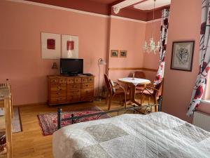 Schlafzimmer mit einem Bett, einem Tisch und einem TV in der Unterkunft Villa Schulenburg in Putbus auf Rügen in Putbus