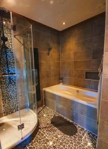 Das Bad ist mit einer Dusche und einer Badewanne ausgestattet. in der Unterkunft The Barn - Aurora Hoeve - loft met jacuzzi in Oldekerk