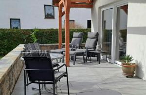 a patio with chairs and tables and windows at PERO in Eldenburg
