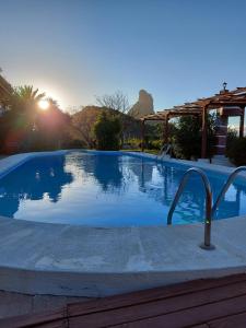 a swimming pool with the sun setting in the background at Chalets Rurales Bentayga in Tejeda