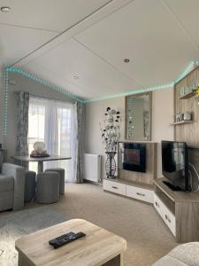 sala de estar con sofá y TV en Skye Breaks en Sheerness