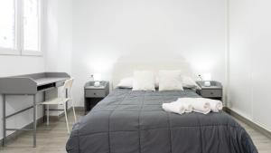 een slaapkamer met een bed met twee witte handdoeken erop bij Apartamento La Paloma Málaga in Málaga