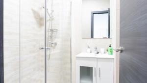 een witte badkamer met een douche en een wastafel bij Apartamento La Paloma Málaga in Málaga
