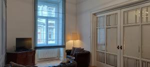 sala de estar con sofá y ventana grande en Center Gold Apartment en Budapest