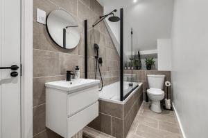 une salle de bain avec un lavabo, des toilettes et un miroir dans l'établissement Princes Wharf, Stylish 2 Bed City Centre Apartment, à Newcastle upon Tyne 27 autres photos