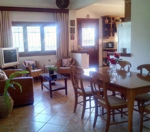 un soggiorno con tavolo e una sala da pranzo di Villa Rose Garden ad Ágios Ioánnis
