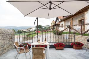 stół i krzesła z parasolem na patio w obiekcie Apartamentos Nordeste w mieście Trasierra