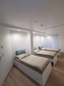 three beds in a room with white walls at Haus am Nymphensee2 in Brieselang