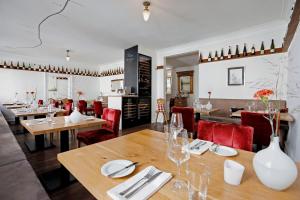 uma sala de jantar com mesas de madeira e cadeiras vermelhas em WEINreich, Gästezimmer & Weinstube em Freinsheim