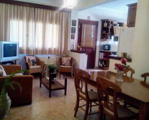 salon ze stołem i jadalnią w obiekcie Villa Rose Garden w mieście Ágios Ioánnis