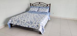 uma cama com um cobertor e almofadas azuis e brancas em Bertam Homestay Kepala Batas em Kepala Batas