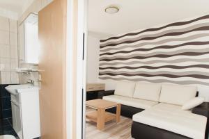 a living room with a couch and a wave mural at Apartments Toka in Petrcane +49 photos