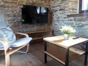 a living room with a tv and a table and a chair at Casa Guillermo in Barreiros